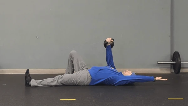 Coach Ryan demonstrates the setup for the kettlebell arm bar.
