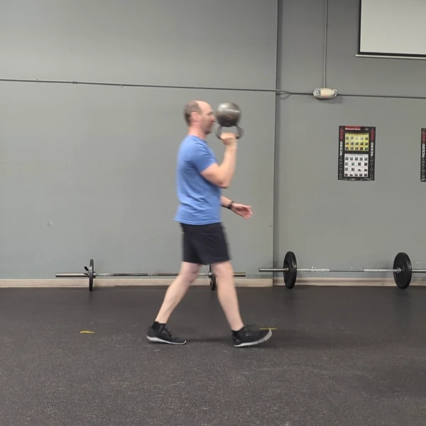 Coach Ryan demonstrates a bottom-up rack carry with a kettlebell.