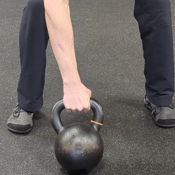 Coach Ryan shows the kettlebell hand's placement in the center grip (pronated view).
