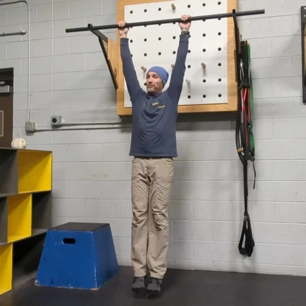 Coach Ryan demonstrates a good dead hang with packed shoulders.