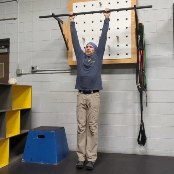 Coach Ryan demonstrates a bad dead hang with unpacked shoulders.