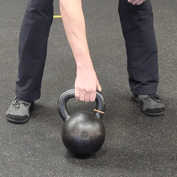Coach Ryan shows the kettlebell handle's placement in the finger grip (pronated view).