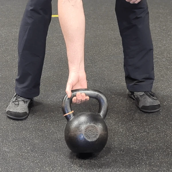 Coach Ryan shows the kettlebell handle's placement in the finger grip (supinated view).
