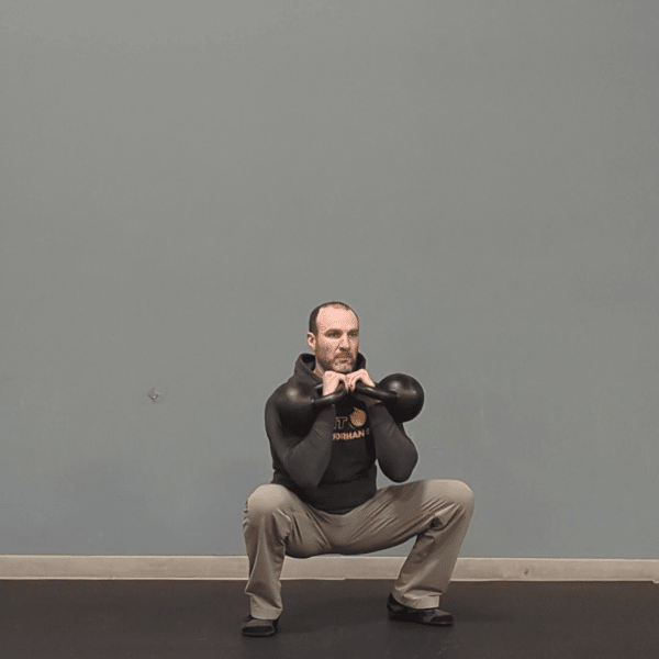 Coach Ryan demonstrates good mechanics in the bottom position of a double kettlebell front squat.