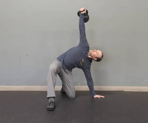 Coach Ryan demonstrates a not-so-good position of the hand and legs in the half-kneeling portion of the getup—legs are aligned instead of at 90 degrees.