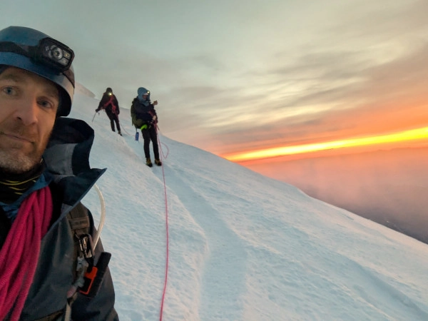 Coach Ryan and two partners stand on the Ingraham Glacier on Mt. Rainier's DC route (to the summit).