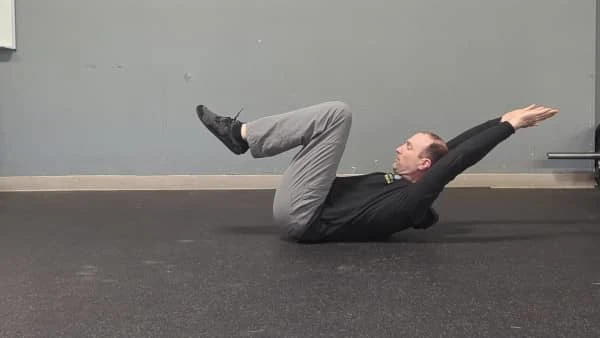 Coach Ryan demonstrates a bent-leg hollow hold.