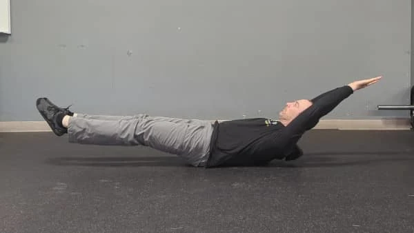 Coach Ryan demonstrates a straight-leg hollow hold.