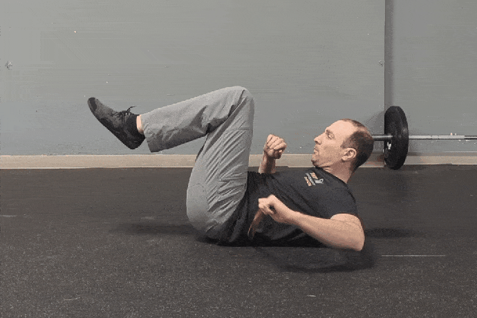 Coach Ryan demonstrates a flattened lumbar spine position.