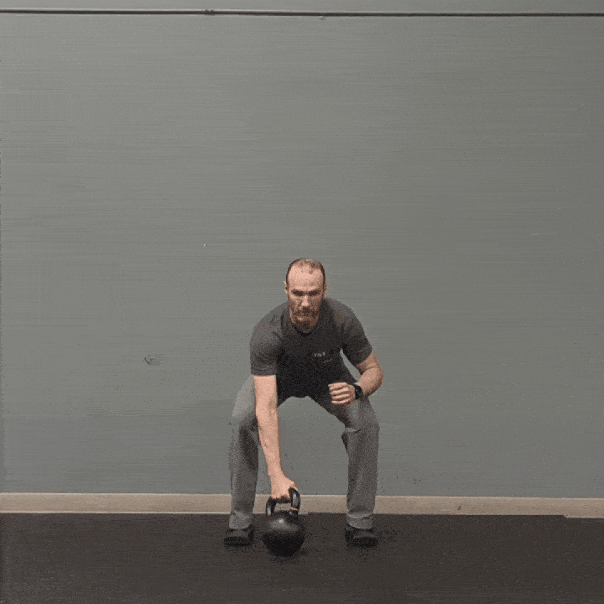 Coach Ryan demonstrates a kettlebell military press.