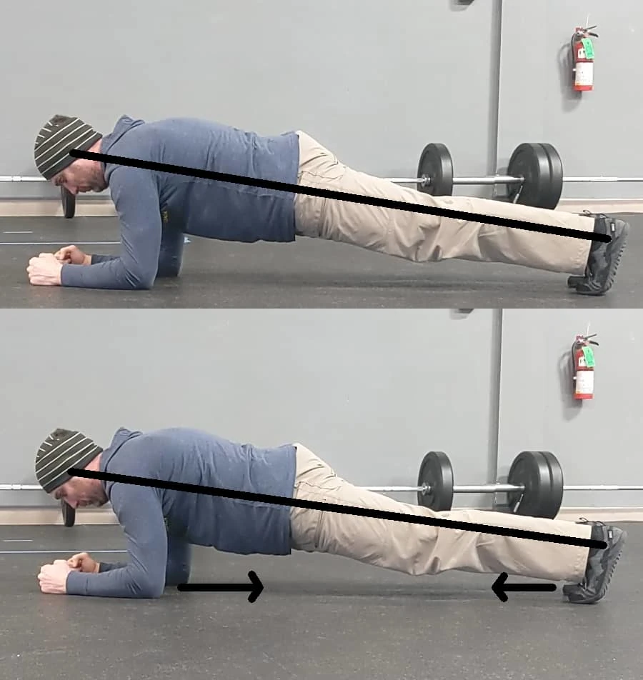 Coach Ryan demonstrates an optimal plank position: straight line from the crown of the head to the heels, with tension directed backward from the elbows and forward from the toes.