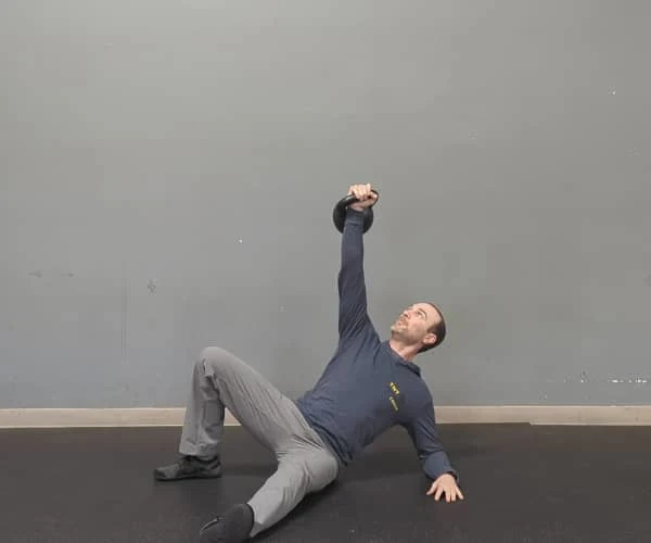 Coach Ryan demonstrates packed shoulders while doing a getup.