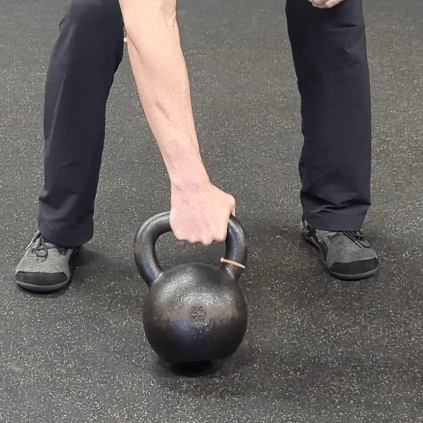 Coach Ryan shows the kettlebell handle's placement in the palm grip (pronated view).
