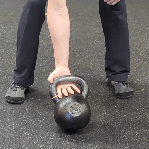 Coach Ryan shows the kettlebell handle's placement in the palm grip (supinated view).