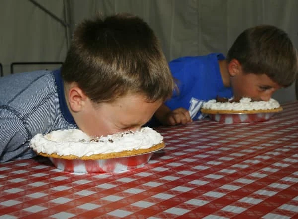 Two boys stuffing their faces in pies during a pie-eating contest. (Image courtesy of Arizona State Fair)