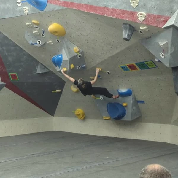 Coach Ryan's climbing partner, Lizzie, stretches out on an overhung bouldering problem.