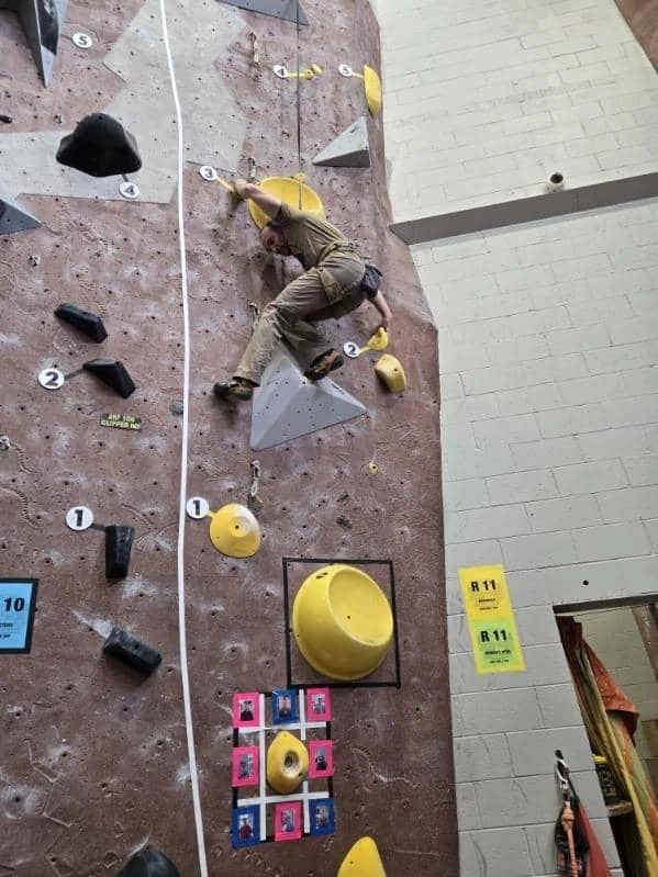 Coach Ryan climbs an indoor route at Adventure Rock's annual Quick on the Draw climbing competition.