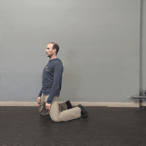 Coach Ryan demonstrates a common Reverse Nordic Curl error: flexing the hips on the way up.