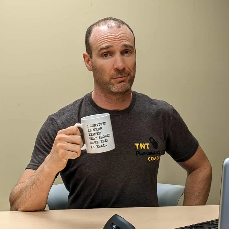 Coach Ryan holds a coffee mug that reads: "I survived another meeting that should have been an email".