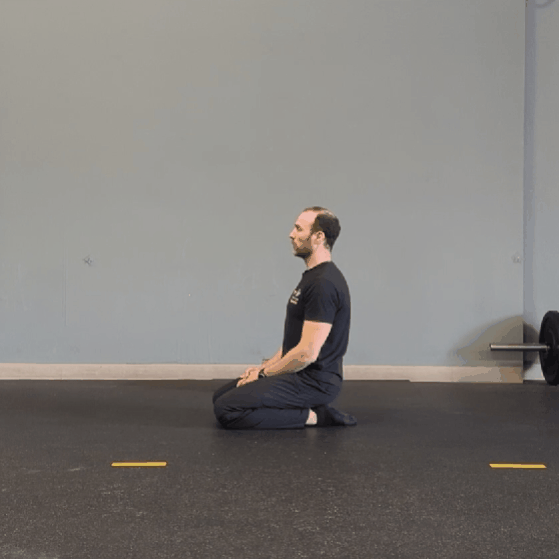 Coach Ryan demonstrates two versions of Seiza—sitting back on the ankles from a kneeling position.