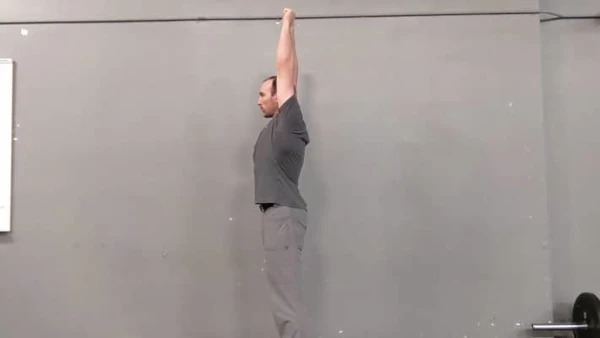 Coach Ryan holds his straight arms overhead to demonstrate a shoulder mobility test.