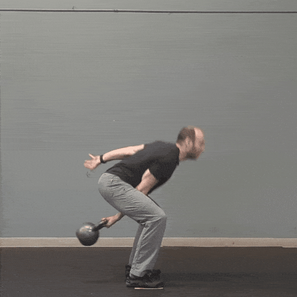 Slow motion of Coach Ryan snatching a kettlebell.