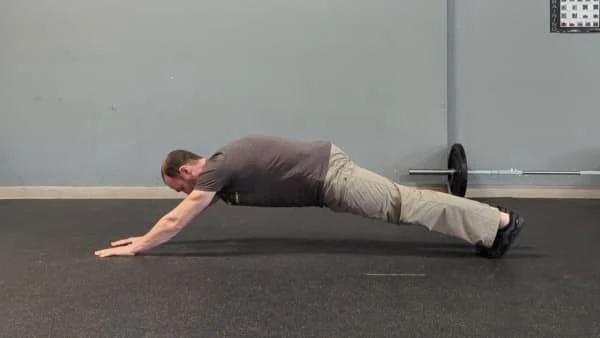 Coach Ryan demonstrates a Superman plank.