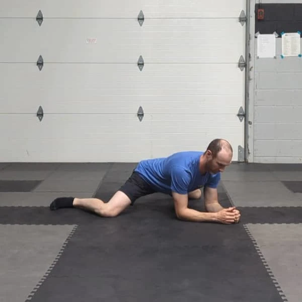 Coach Ryan demonstrates the basic Tactical Frog hip stretch.