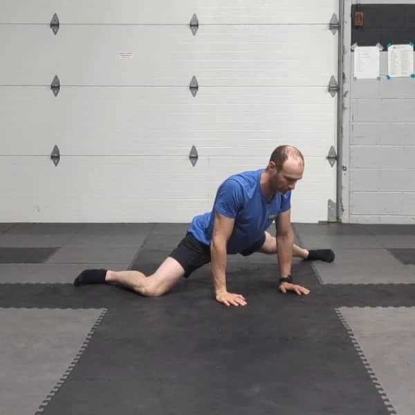 Coach Ryan demonstrates a straight-leg variation of the Tactical Frog on the hands.