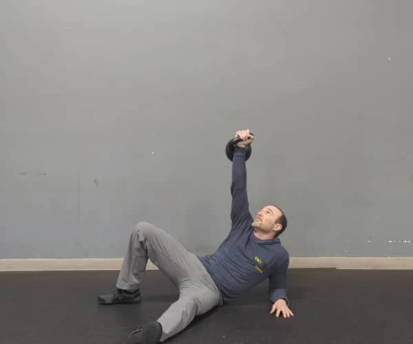 Coach Ryan demonstrates unpacked shoulders while doing a getup.